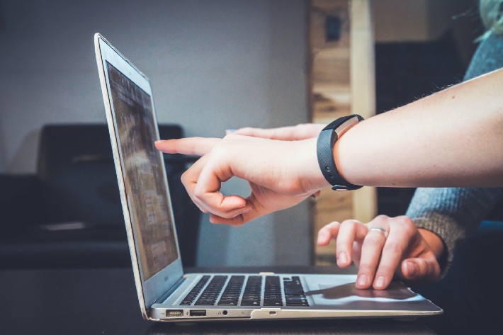 laptop with someone pointng to screen